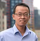 Man with Blue shirt and Buildings in the Background