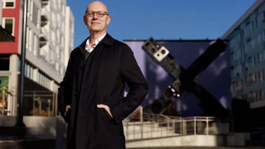 johnrubino Man in Black Jacket Standing Outside a Building