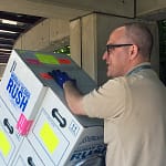 tom-volunteer-web Bloodworks Courier Transporting Boxes of Donated Blood with a Dolly