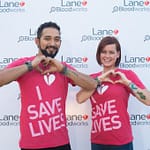 37208520681_fefc144b46_k Image of a man and a woman wearing shirts that say "I save lives" making their hands into hearts