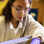 a19_4592 Image of a woman in a laboratory wearing gloves and protective goggles