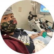Person Donating Platelets While Lying in a Medical Chair Wearing a Camouflage Mask.