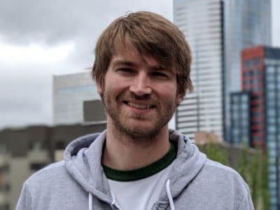 00100dportrait_00100_burst20180621112036220_cover Photo of a man in a hooded sweatshirt against the Seattle skyline