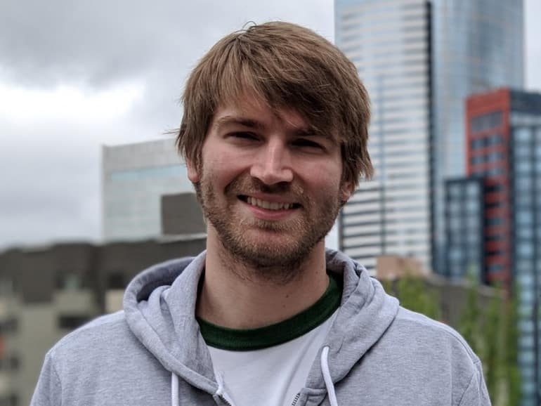 00100dportrait_00100_burst20180621112036220_cover Photo of a man in a hooded sweatshirt against the Seattle skyline